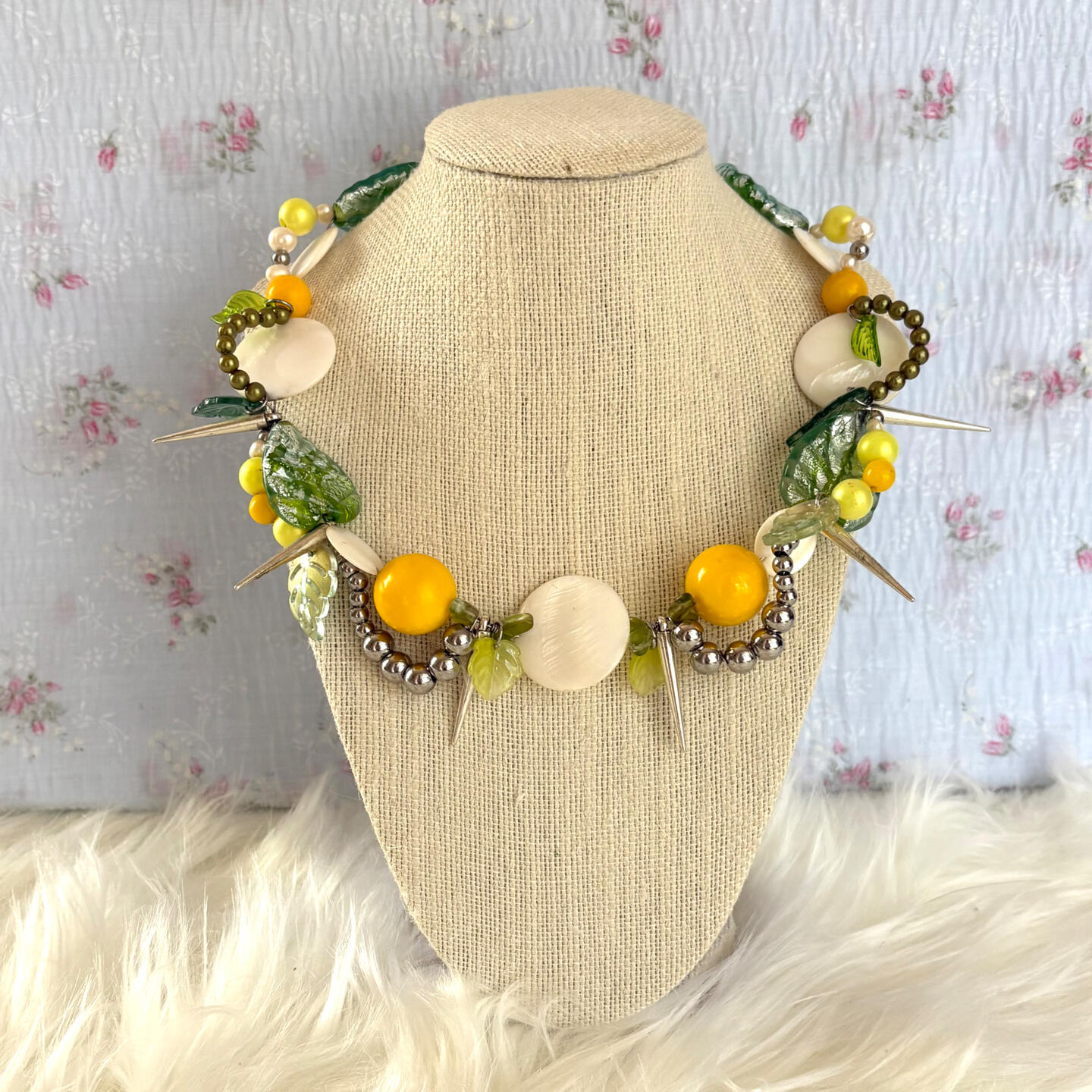 this piece pays homage to days spent picking daisies, and the ambitions they represented. constructed using spike pendants, shell slices, glass leaves, acrylic beads, freshwater pearls, and stainless steel hardware.